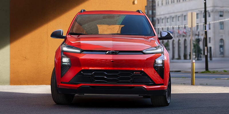 Red Chevrolet Bolt parked on a city street.
